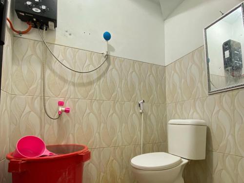 a bathroom with a toilet and a red trash can at Villa Harga Terjangkau di Malang in Malang