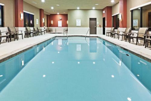 a large swimming pool with chairs and tables at Holiday Inn Hotel & Suites Tulsa South by IHG in Tulsa