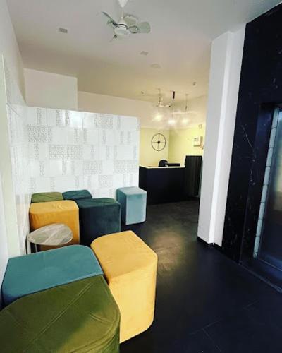 een wachtkamer met kleurrijke stoelen en een aanrecht bij hotel harijyot in Pusad