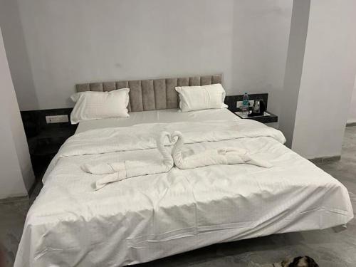 een bed met twee zwanen gemaakt van handdoeken bij hotel harijyot in Pusad