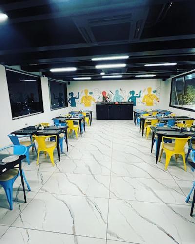 een eetkamer met tafels en gele stoelen bij hotel harijyot in Pusad