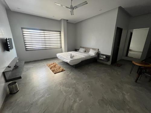 hotel harijyot في Pusad: غرفة نوم فيها سرير ونافذة