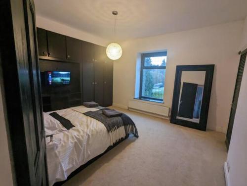 a large bedroom with a bed and a mirror at 2 BDR House - Ideal for Short Breaks & Contractors in Rochdale