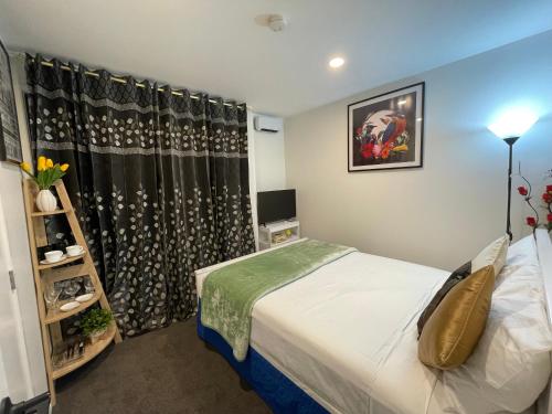 Habitación pequeña con cama y ventana en Auckland CBD, Parnell Ensuite+Patio+Secluded Garage, en Auckland