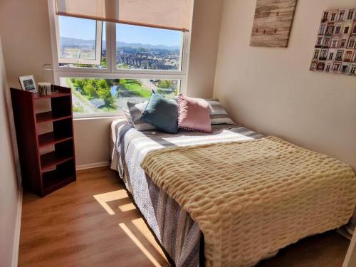 a bedroom with a bed with a large window at Hermoso y soleado departamento a pasos de casino Marina del Sol in Talcahuano