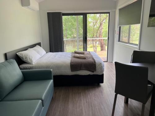 a bedroom with a bed and a couch at Denman Van Village in Denman