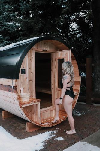 a woman in a bikini standing in a wooden dog house at Tantalus Resort Lodge in Whistler