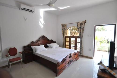 a bedroom with a large bed and a window at Kukunjang in Banjul