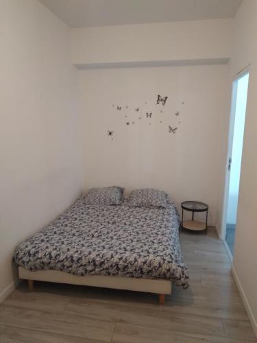 une chambre avec un lit dans une pièce blanche dans l'établissement Appartement Périgord blanc, à Mussidan