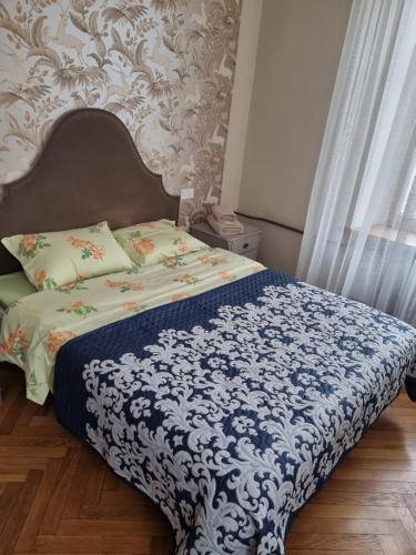 a bedroom with a bed with a blue and white blanket at Al Pacino apartment in Riga