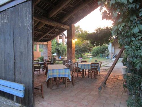 an outdoor patio with tables and chairs and a wooden pavilion at Agriturismo La Tilia in Lequio Tanaro