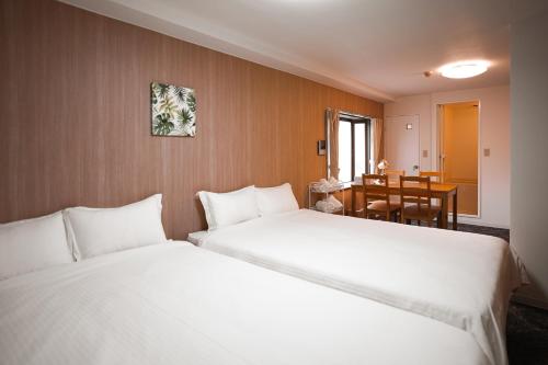 - 2 lits blancs dans une chambre avec une table dans l'établissement TuTuLu302, à Osaka