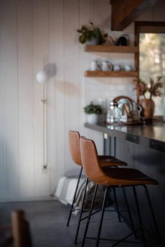 a kitchen with two chairs and a counter top at Mid-Century Cabin Perfect for Romantic Getaway in Running Springs