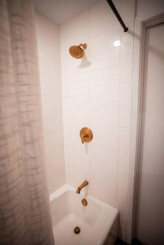 a white bathroom with a tub and a sink at Mid-Century Cabin Perfect for Romantic Getaway in Running Springs