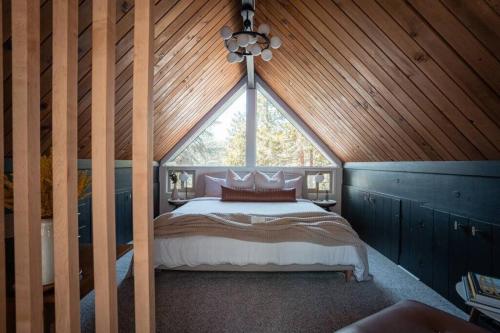 a bedroom with a bed in a wooden ceiling at Mid-Century Cabin Perfect for Romantic Getaway in Running Springs