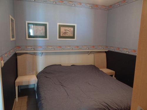 ein kleines Schlafzimmer mit einem Bett und zwei Stühlen in der Unterkunft Seasight A0303 with sea view in Nieuwpoort