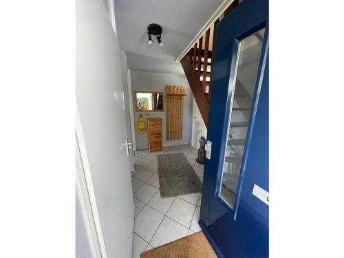 einen Flur mit blauer Tür und einer Treppe in der Unterkunft Holiday home Watersnip 5 in Lemmer