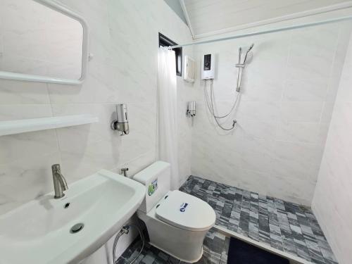La salle de bains est pourvue de toilettes, d'un lavabo et d'une douche. dans l'établissement Prairie Cottage Khaoyai, à Pak Chong