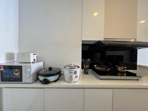 a kitchen counter with a microwave and a stove at QUINCE HOME GRAND ION DELEMEN GENTING HIGHLANDs in Genting Highlands