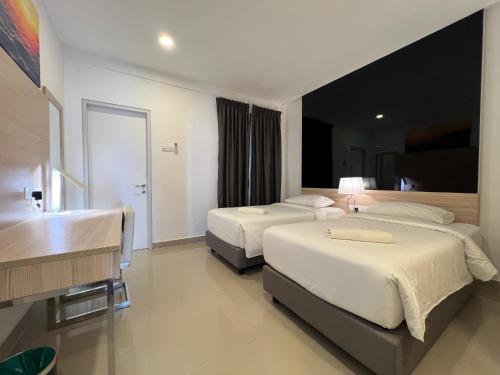 a hotel room with two beds and a desk at QUINCE HOME GRAND ION DELEMEN GENTING HIGHLANDs in Genting Highlands