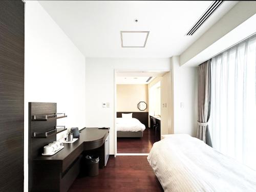 a hotel room with a bed and a desk and a bedroom at KOKO HOTEL Sendai Kotodai Park in Sendai