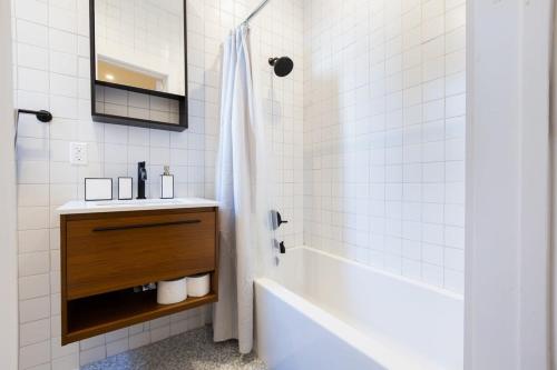 La salle de bains est pourvue d'une baignoire, d'un lavabo et d'une douche. dans l'établissement 7-3 2BR 1Bath in Prime Park Slope, à Brooklyn