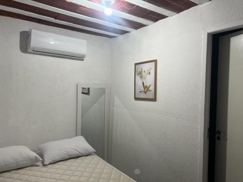 a small bedroom with a bed and a ceiling at Suite 3, Casa Amarela, Terceiro Andar in Nova Iguaçu