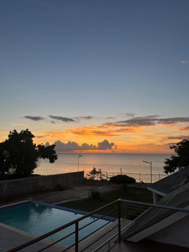a sunset over the ocean with a swimming pool at Beachscape At Black River in Black River