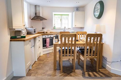 a kitchen with a wooden table and two chairs at 2 Riverside in Barnard Castle