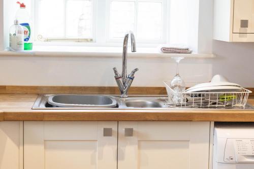 a kitchen sink with a dish drying rack next to it at 2 Riverside in Barnard Castle