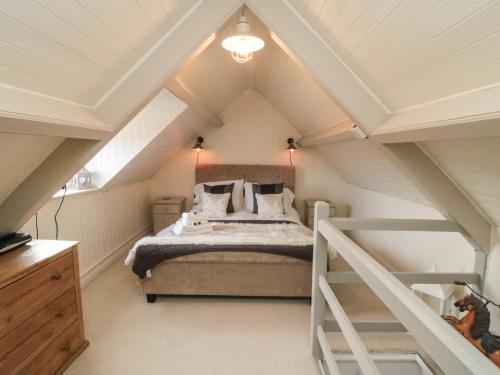 a bedroom with a bed in the attic at Harriet's Cottage in Whitby