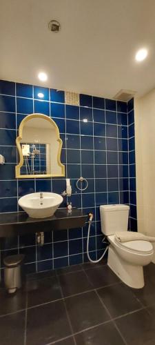 uma casa de banho em azulejos azuis com um WC e um lavatório em Cafe de Paris em Praia de Patong