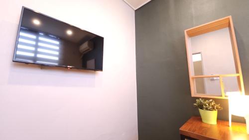 a flat screen tv on a wall next to a mirror at OYO Hostel Dongdaemun1 in Seoul