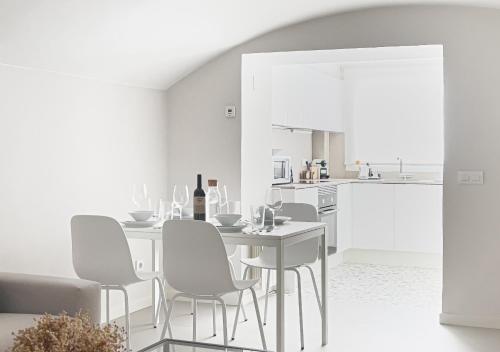 a white dining room with a white table and chairs at Majordoms - Ca les Cosines 48 in Banyoles