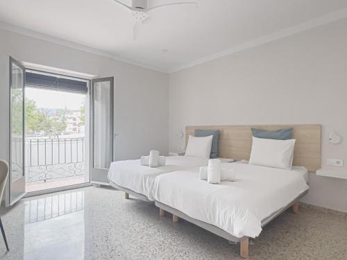 two beds in a white room with a window at Majordoms - Ca les Cosines 48 in Banyoles