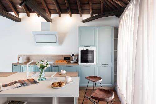 una cocina con armarios azules y una mesa y sillas blancas. en Gandesa, Palace House en Sevilla