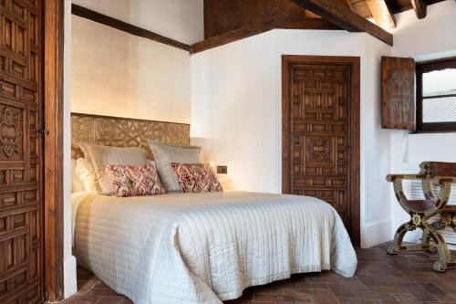 a bedroom with a bed and a wooden door at Gandesa, Palace House in Seville