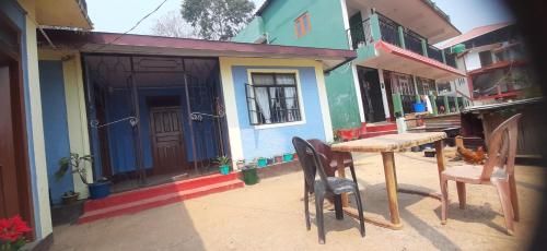 uma mesa e cadeiras em frente a uma casa em Aarav Homestay em Kalimpong