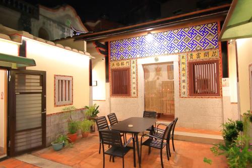 a patio with a table and chairs in front of a building at Yong Le Homestay in Jincheng