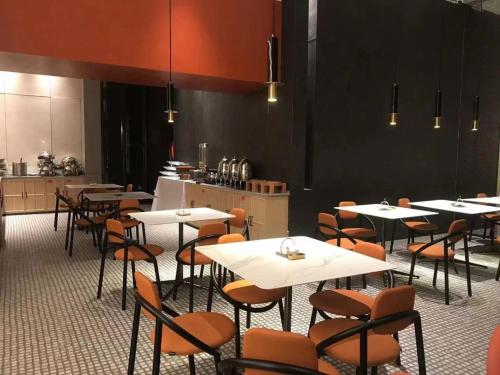un ristorante con tavoli e sedie e una cucina di Mito Serviced Apartment a Canton