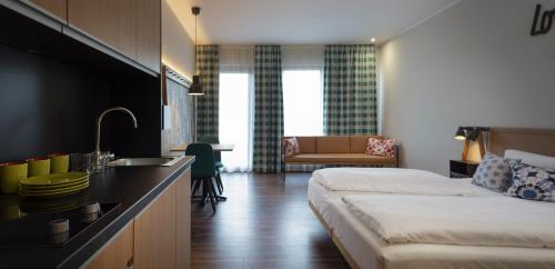 a room with a bed and a kitchen with a sink at Mjus Resort & Thermal Park in Körmend
