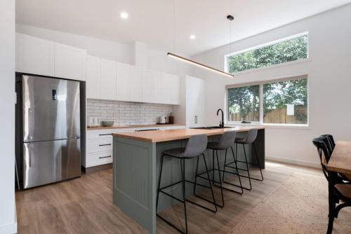 a kitchen with a island with bar stools and a refrigerator at Home sweet home with secure parking in Franklin Village