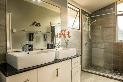 a bathroom with two sinks and a shower at B's Beach House on Muri Lagoon in Rarotonga