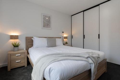 um quarto com uma grande cama branca e uma mesa de cabeceira em Home sweet home with secure parking em Franklin Village
