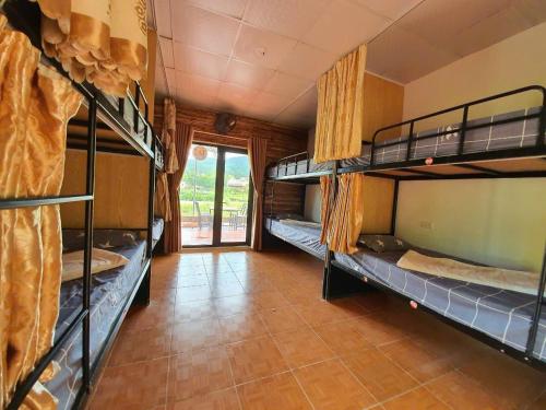 a room with three bunk beds and a tiled floor at Ha Giang Garden Bungalow in Ha Giang