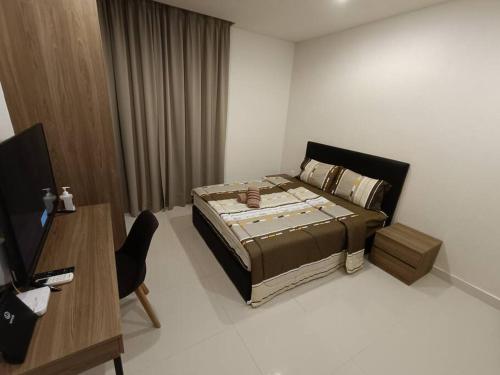 - une chambre avec un lit, une table et un bureau dans l'établissement Kozi Square Aurora Homestay L7, à Kuching