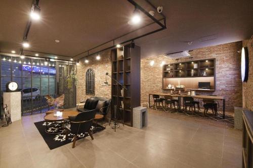 Una sala de estar con sillas y un comedor. en Hotel Gray, en Busan