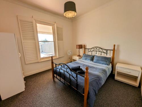 a bedroom with a bed and a window at The Astra Broken Hill in Broken Hill