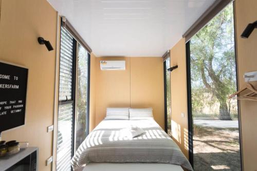 Cama en habitación con ventana grande en Organic Farm Stay, en Numurkah