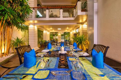 a dining room with a table with blue napkins at The Palace by Ocean in Bentota
